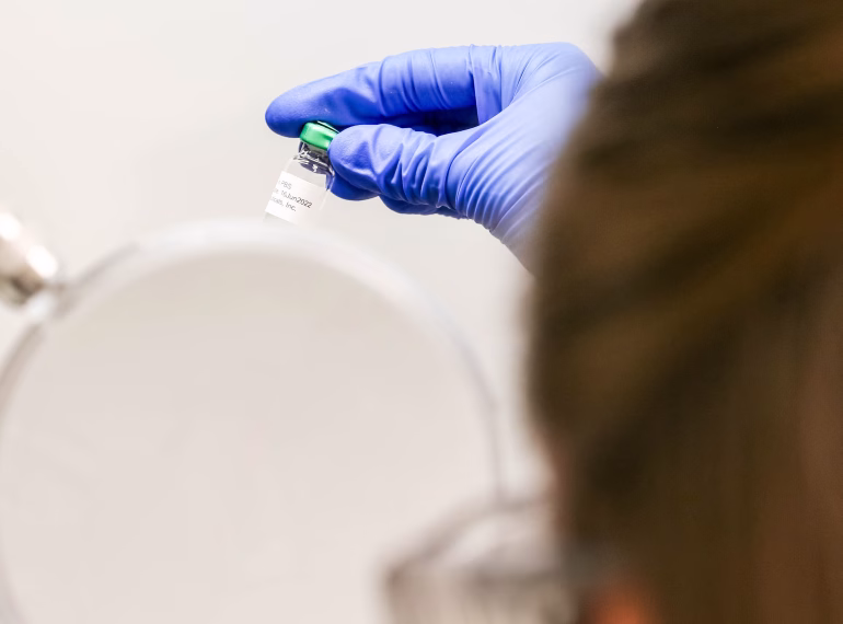 Scientist providing oversight on a manufactured vial