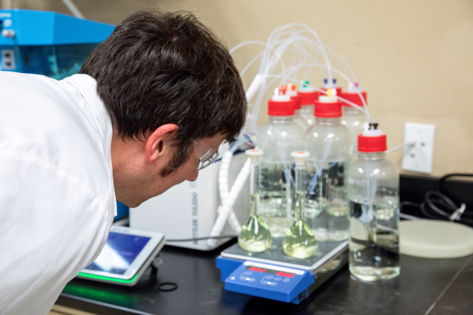 Chemist observing multiple drug formulations in laboratory